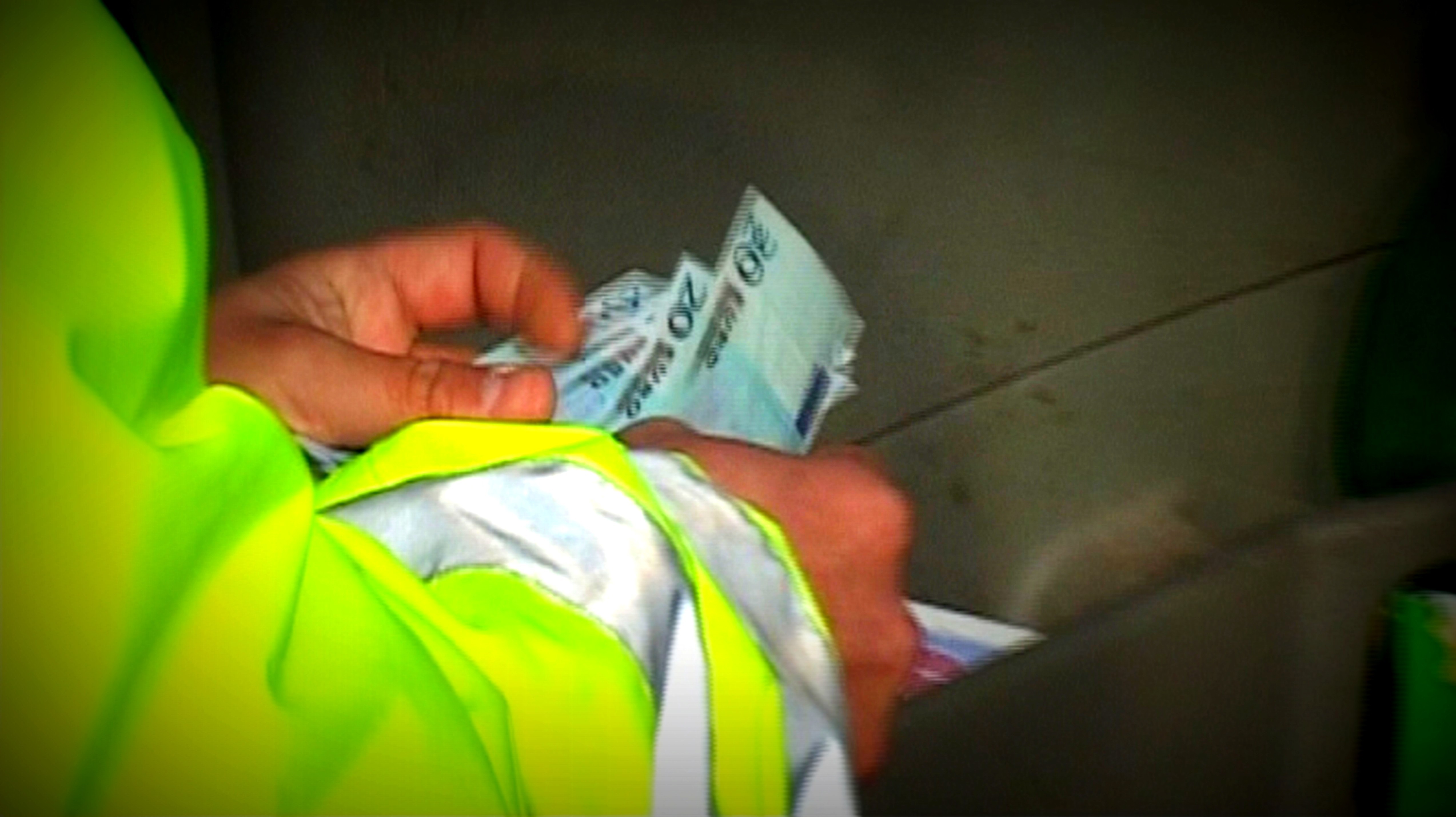 Úplatný policajt preberá peniaze z ruky